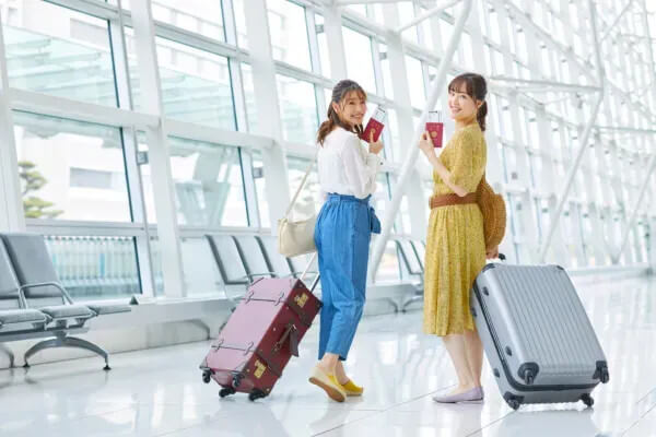 空港で対話する旅行中の女性二人